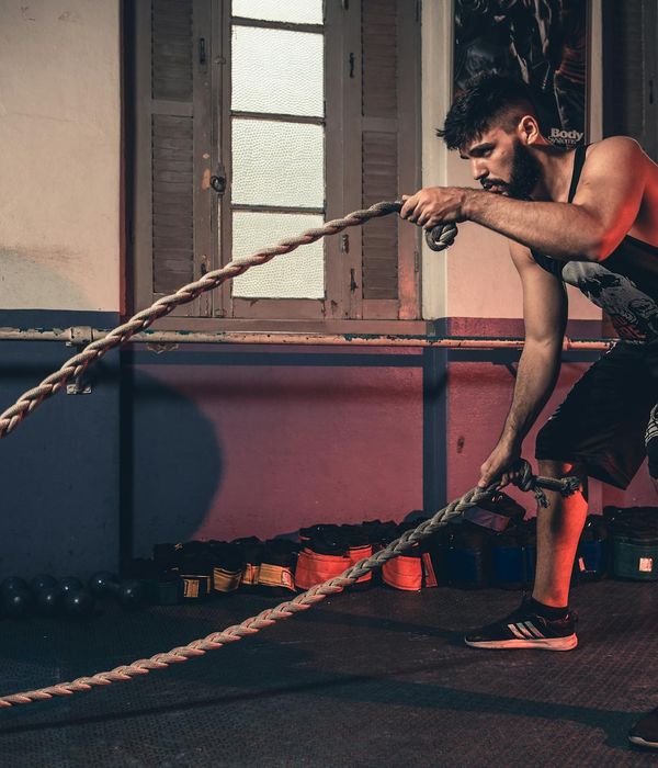 Person in mid-motion during a dynamic cardio exercise in a minimalist studio.
